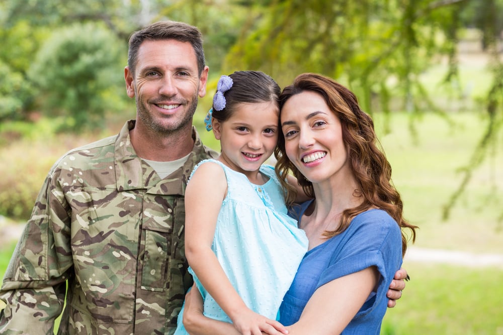 Handsome soldier reunited with family on a sunny day Handsome soldier reunited with family on a sunny day